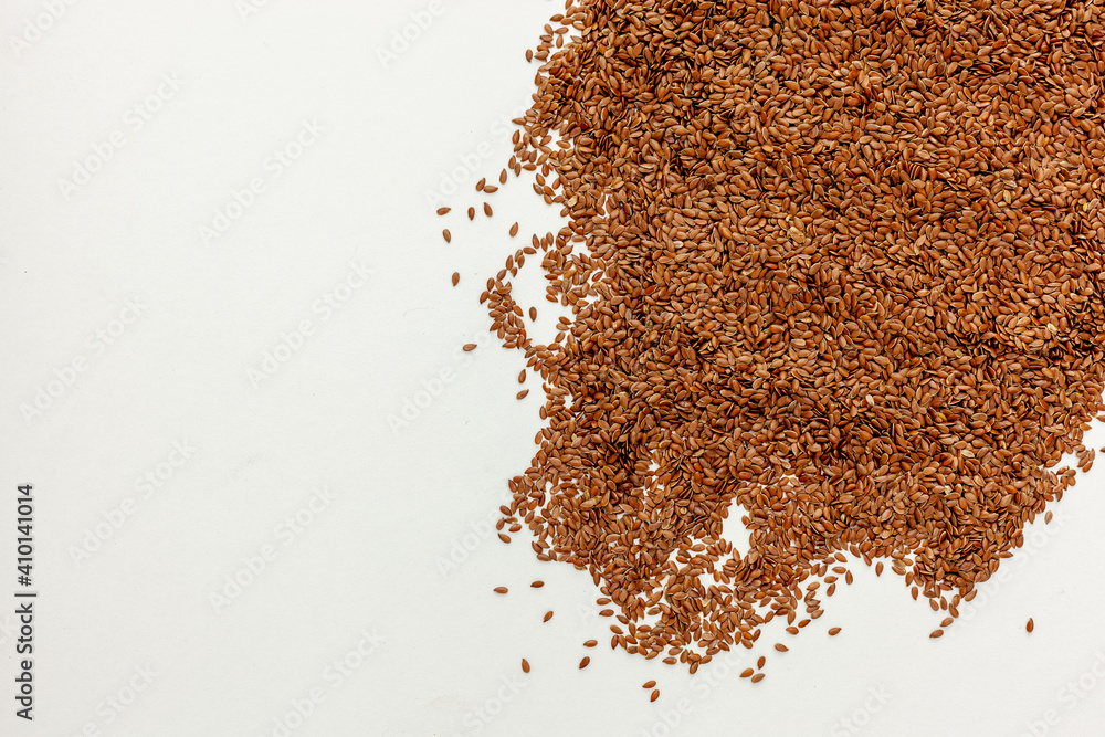 brown Flax seeds scattered on a white table brown Flax seeds scattered on a white table