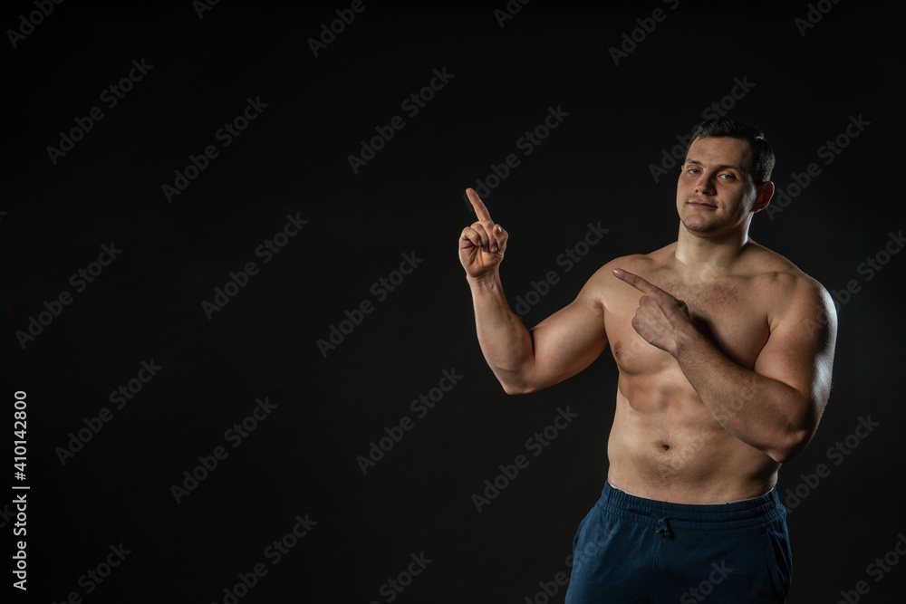 Hands on the belt of a man's bare torso is sexy points up Young man business adult handsome, lifestyle confidence athlete. Studio dumbbell elegance background black bodybuilder