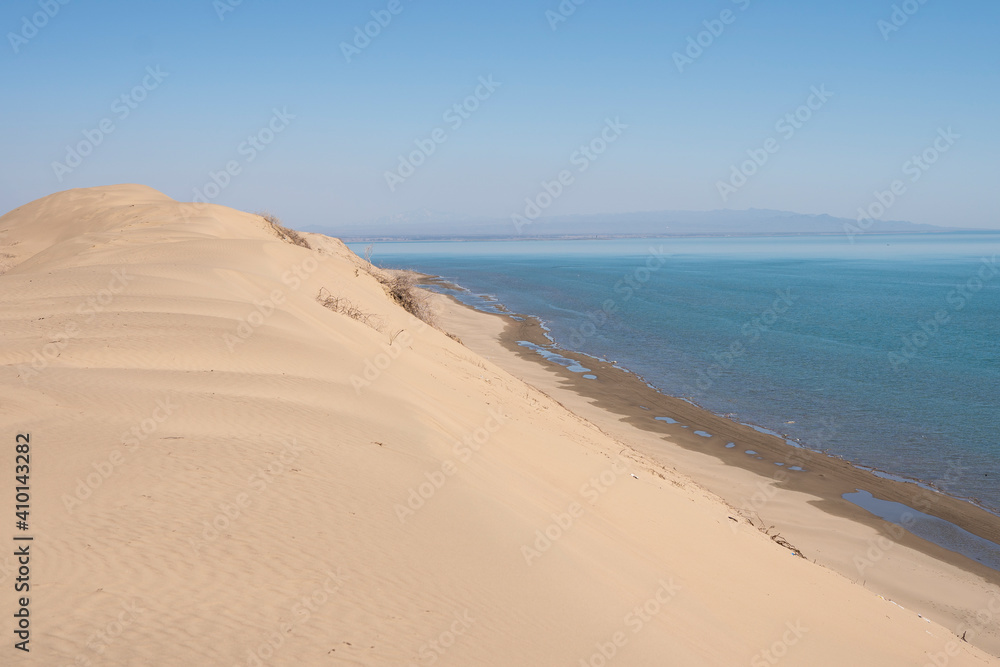Sand dunes near the sea. Sandy ocean shore. Summer rest. Tourism, travel. Landscape, background, photo wallpaper.