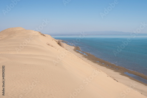 Sand dunes near the sea. Sandy ocean shore. Summer rest. Tourism  travel. Landscape  background  photo wallpaper.