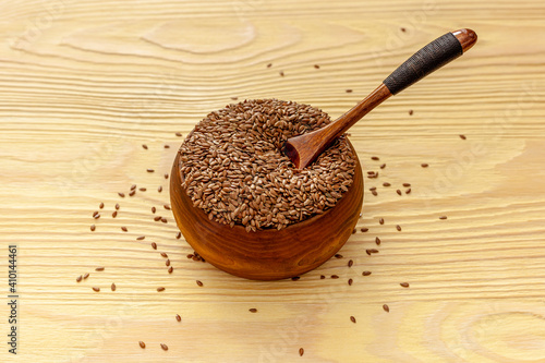Flax seeds in a spoon and bowl with a bottle of flaxseed oil