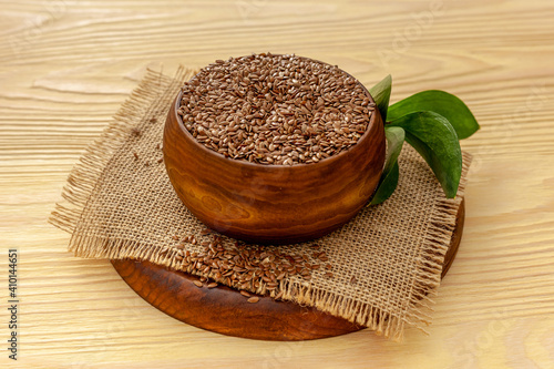 Flax seeds in a spoon and bowl with a bottle of flaxseed oil