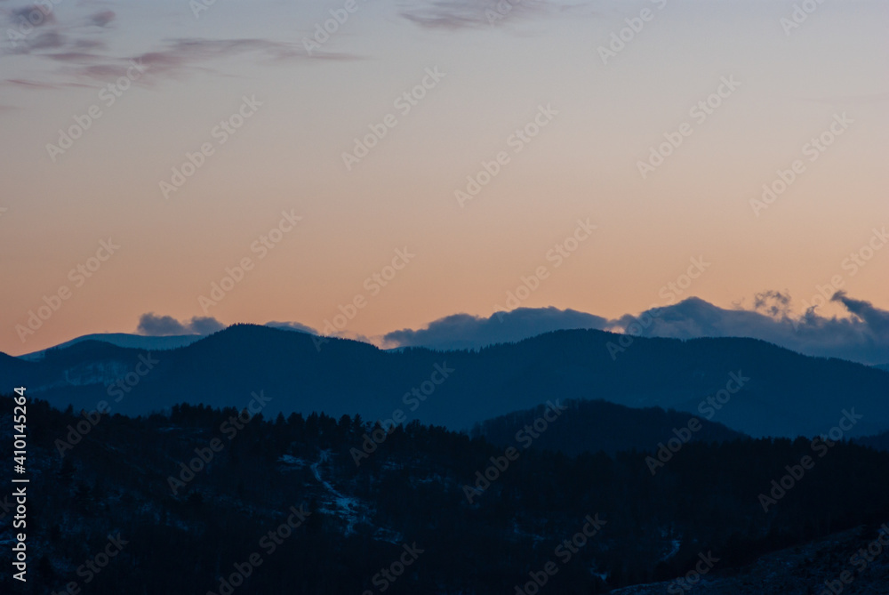 Silhouette of hills and forest at sunset