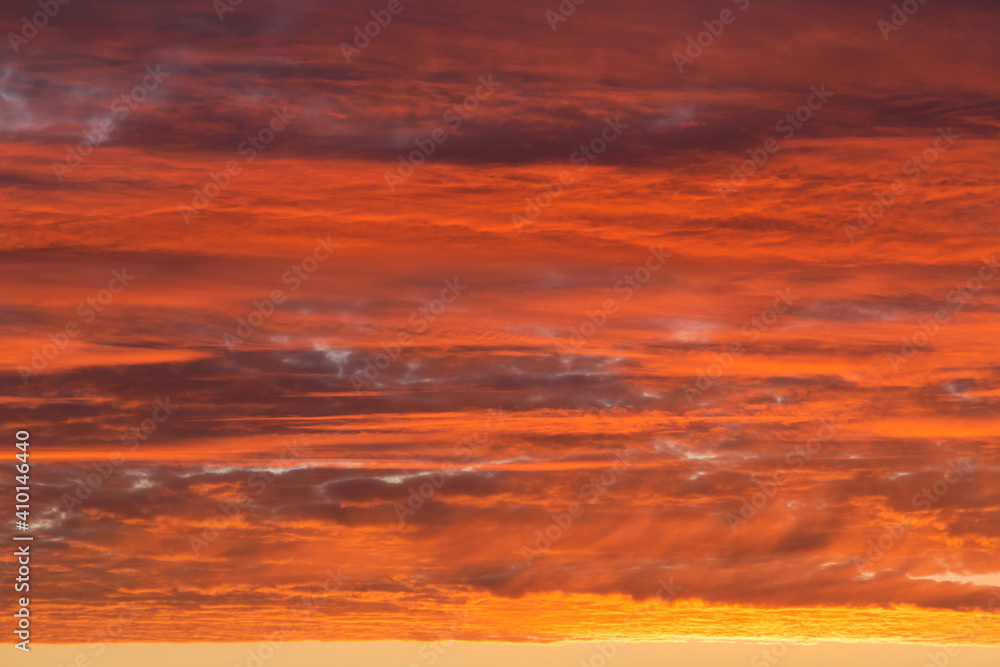 Sunrise, sunset orange yellow pink red sky with clouds background texture