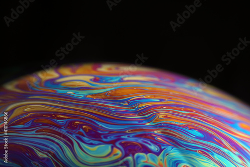 Macro picture of half soap bubble on black ground look like abstract psychedelic color planet in space	