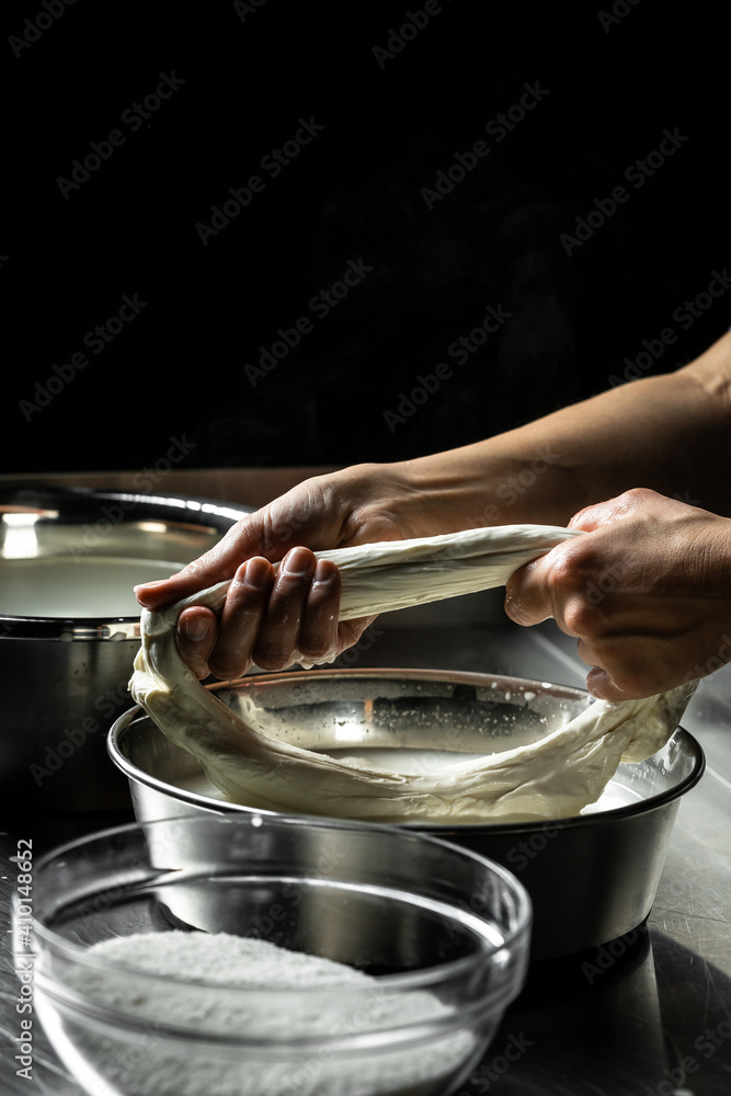 woman working in a small family creamery is processing the final steps of making a cheese, produces handmade mozzarella, silano or caciocavallo. Pasta filata. Close up. Copy space for text woman working in a small family creamery is processing the final steps of making a cheese, produces handmade mozzarella, silano or caciocavallo. Pasta filata. Close up. Copy space for text