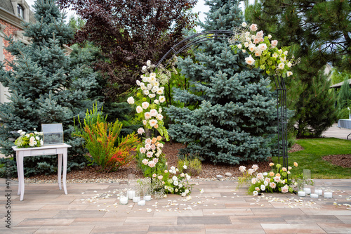an arch of live flowers for an outdoor wedding ceremony. making the holidays