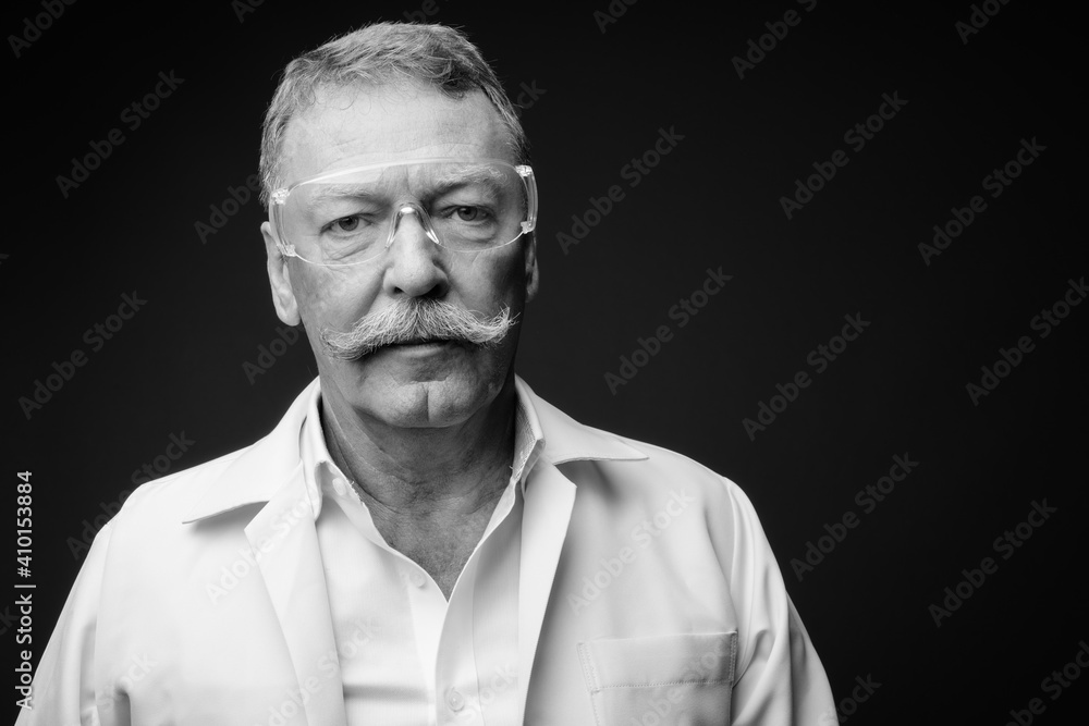 Fototapeta premium Handsome senior man doctor with mustache as scientist