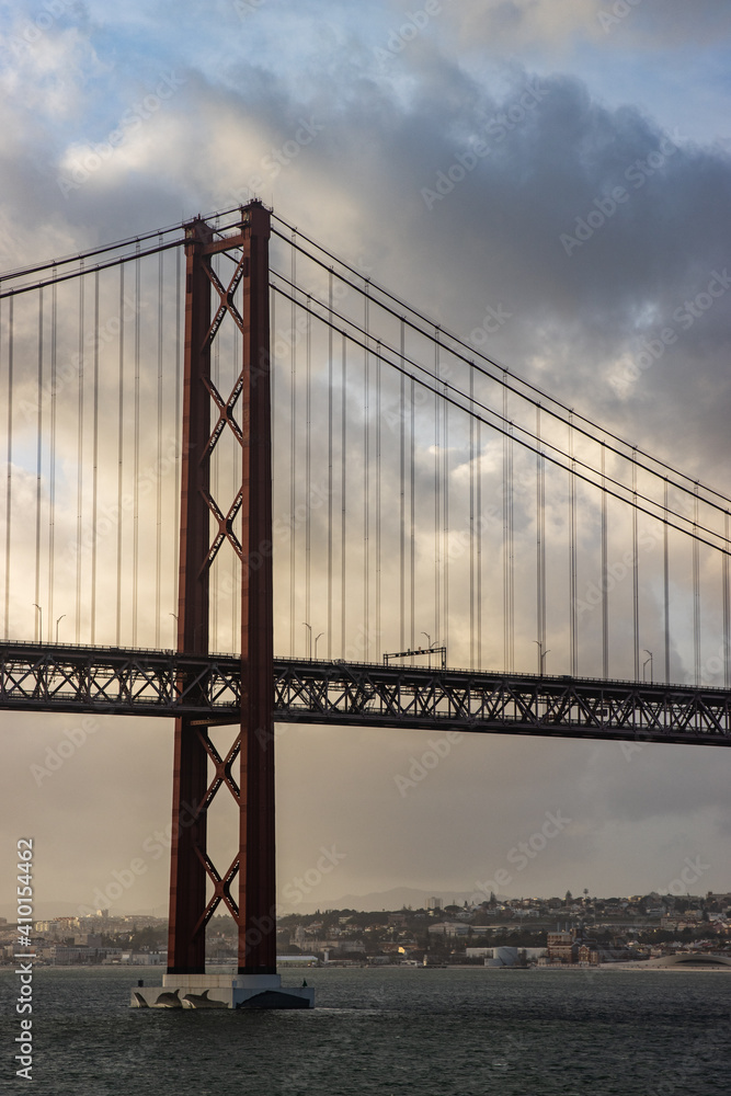 Obraz premium The 25 April bridge (Ponte 25 de Abril) - famous bridge in Lisbon and among of the longest ones in Europe. 