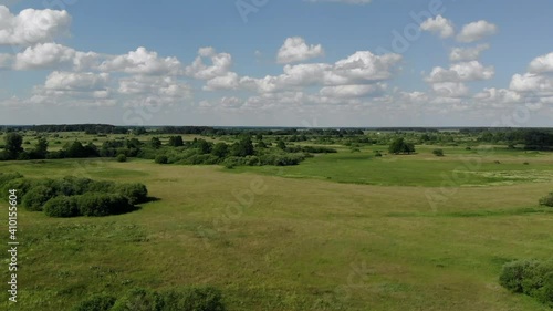 Beautiful aerial view over the curving river along the fields and forest