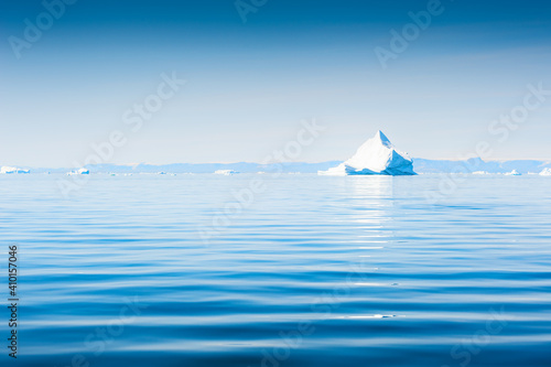 Iceberg in Atlantic ocean. Ilulissat icefjord, west coast of Greenland. Blue sea and the blue sky