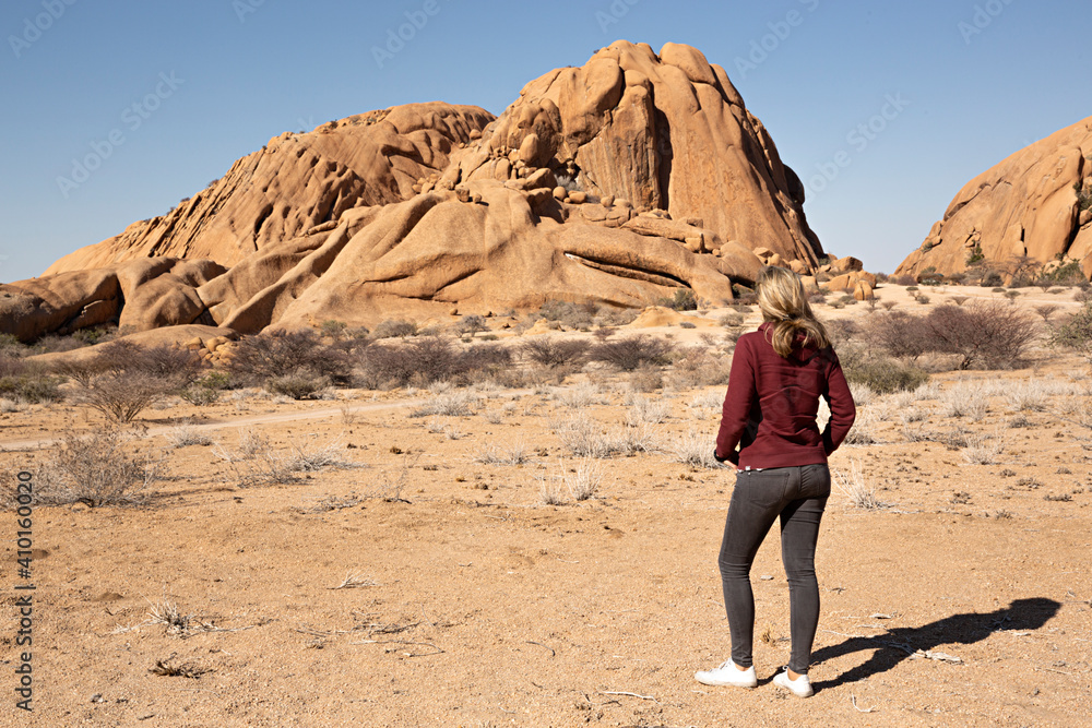 Mujer observando montaña de roca enSpitzkoppe, Namibia.