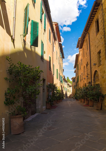 Fototapeta Naklejka Na Ścianę i Meble -  A residential road leads to the Collegiata dei Santi Quirico e Giulitta in the historic medieval village of San Quirico D'Orcia, Siena Province, Tuscany, Italy
