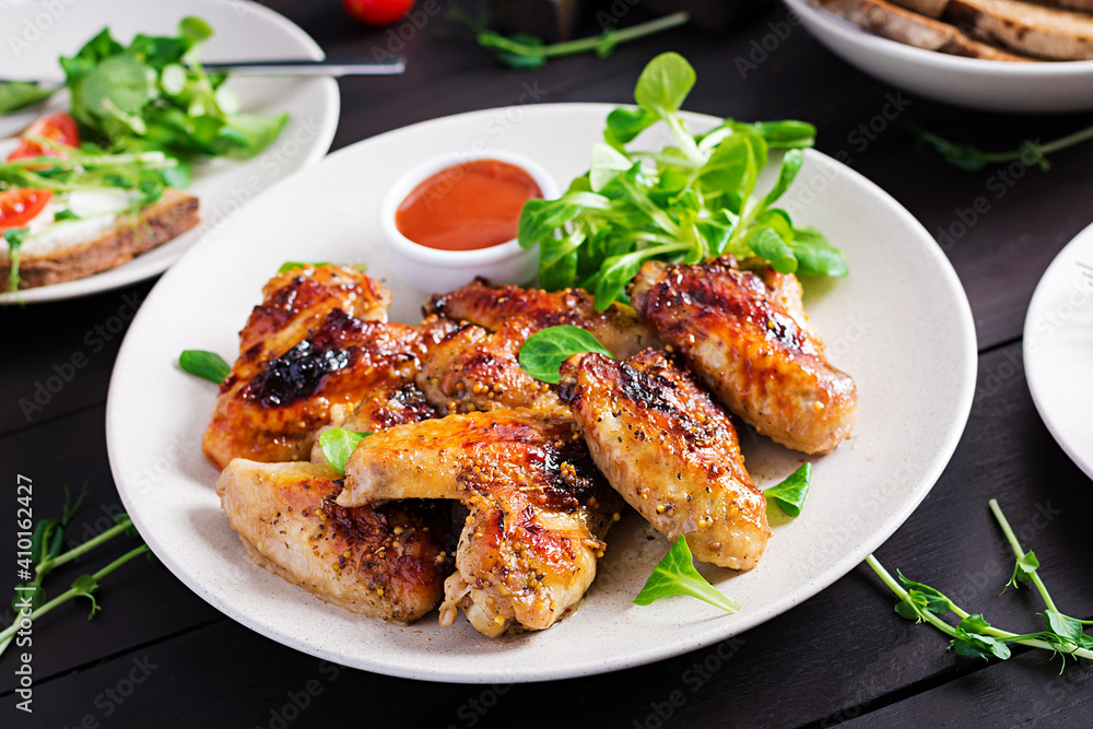 Grilled chicken wings. Baked chicken wings on wooden table. Grilled chicken wings. Baked chicken wings on wooden table.