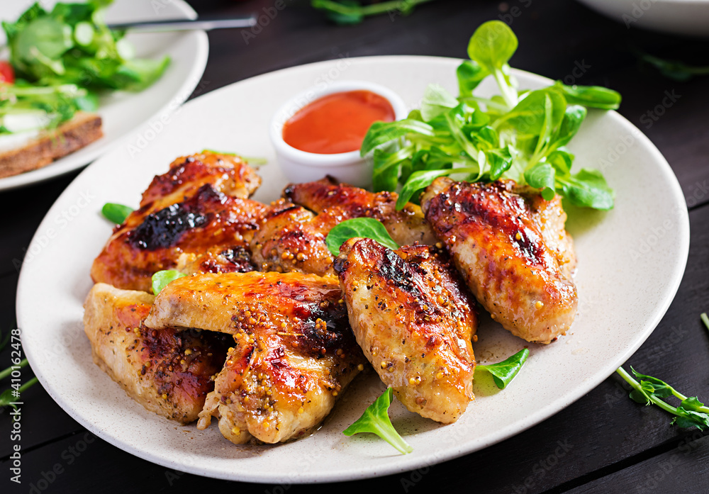 Grilled chicken wings. Baked chicken wings on wooden table.