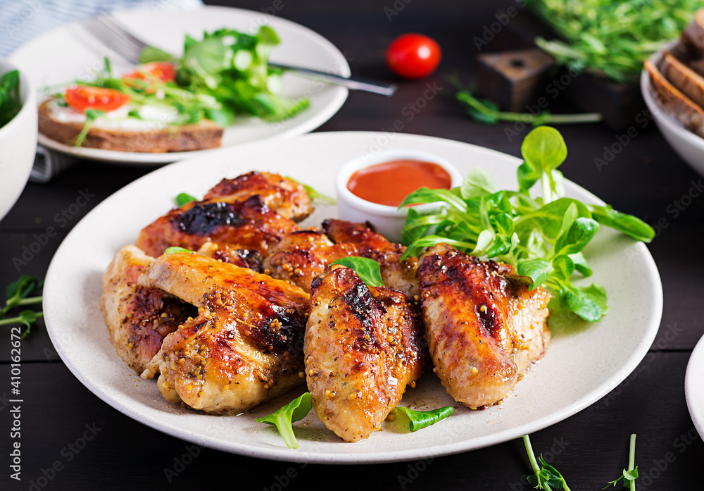 Grilled chicken wings. Baked chicken wings on wooden table.