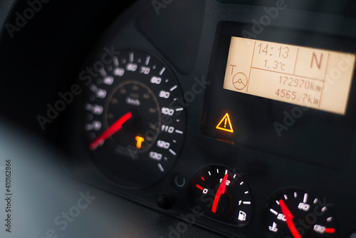 Capital T and steering wheel warning lit on vehicle display of a heavy truck. Digital tachograph indicates 15 minutes left before the driver must take a brake after 4,5 hours of driving. photo