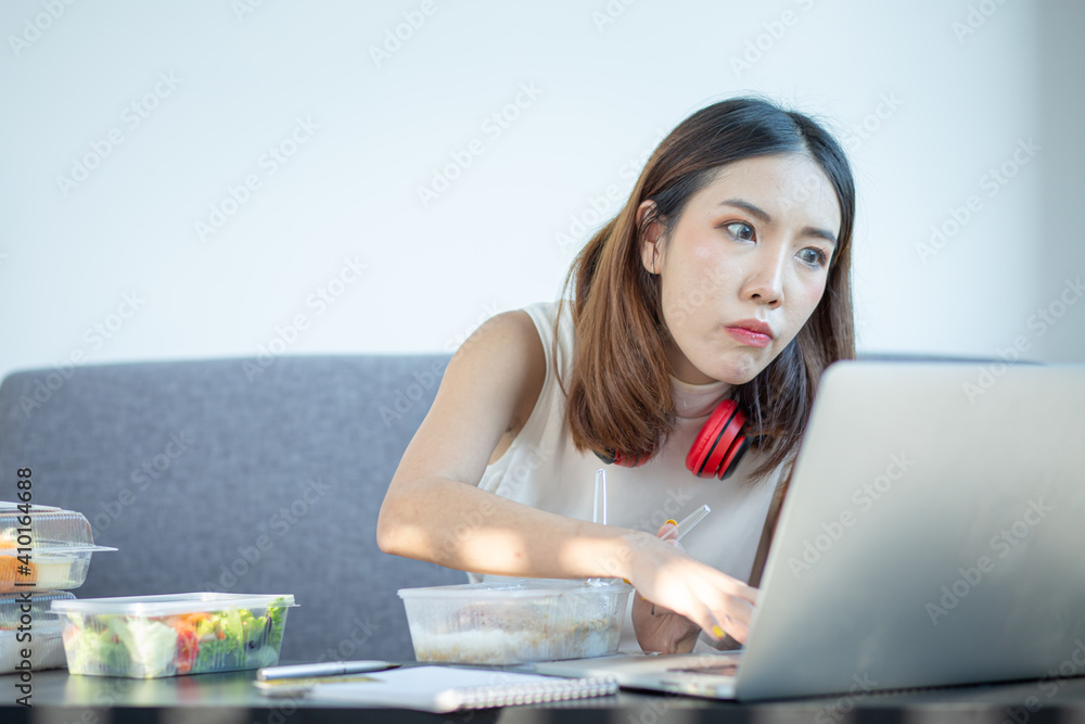 Young attractive asian female hungry eat doughnut take away snack food with full mouth look at computer notebook at home in busy work from home multitask unhealthy meal lifestyle concept.
Young attractive asian female hungry eat doughnut take away snack food with full mouth look at computer notebook at home in busy work from home multitask unhealthy meal lifestyle concept.