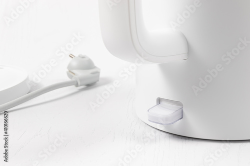 white electric kettle with lid lift button and switch on white background