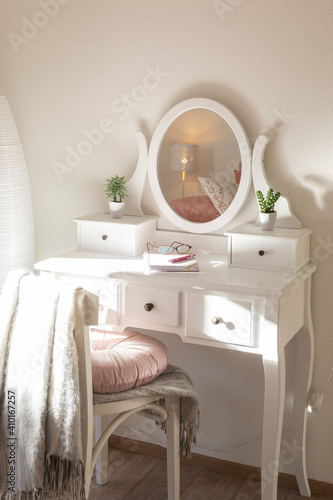 Detail of makeup dressing table with large mirror  diary and organizer. White and clean workstation in the master bedroom