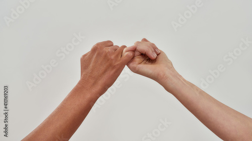 фотографія Close up of two hands hook little finger together to promise or asking for askin