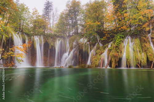 Waterfalls flow into an emerald pool on an autumn day at Plitvice Lakes National Park in Croatia