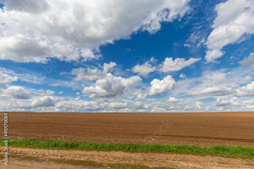 a plowed field against the sky with clouds. Spring sunny day