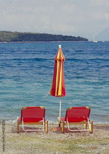 sunbeds and folded sunshade on the coast, Zakynthos island, Greece  photo