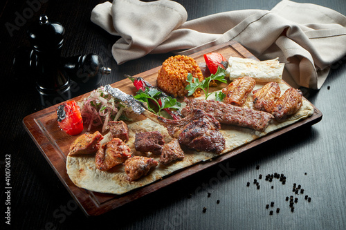 Assorted different types of meat fried over the fire. Skewers of beef, chicken, pork, lamb and kebab with rice and vegetables garnish. Sish kebab photo