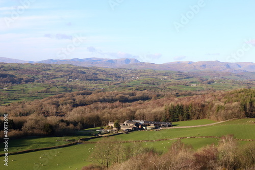 Lyth Valley, Cumbria, UK. View over forest and fields towards fells of the Lake District National Park.