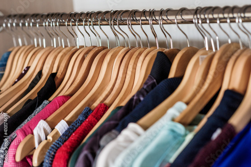 Lots of clothes on hangers, hanging in the closet. Sustainable life and smart consumption