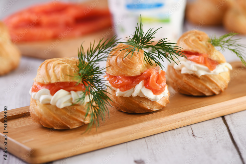 Profiteroles stuffed with cream cheese and salmon, decorated with a sprig of dill. Close-up Profiteroles stuffed with cream cheese and salmon, decorated with a sprig of dill. Close-up