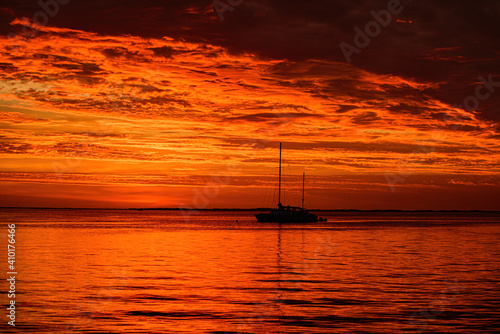 Summer traveling cruise. Sailboats at sunset. Ocean yacht sailing along water.
