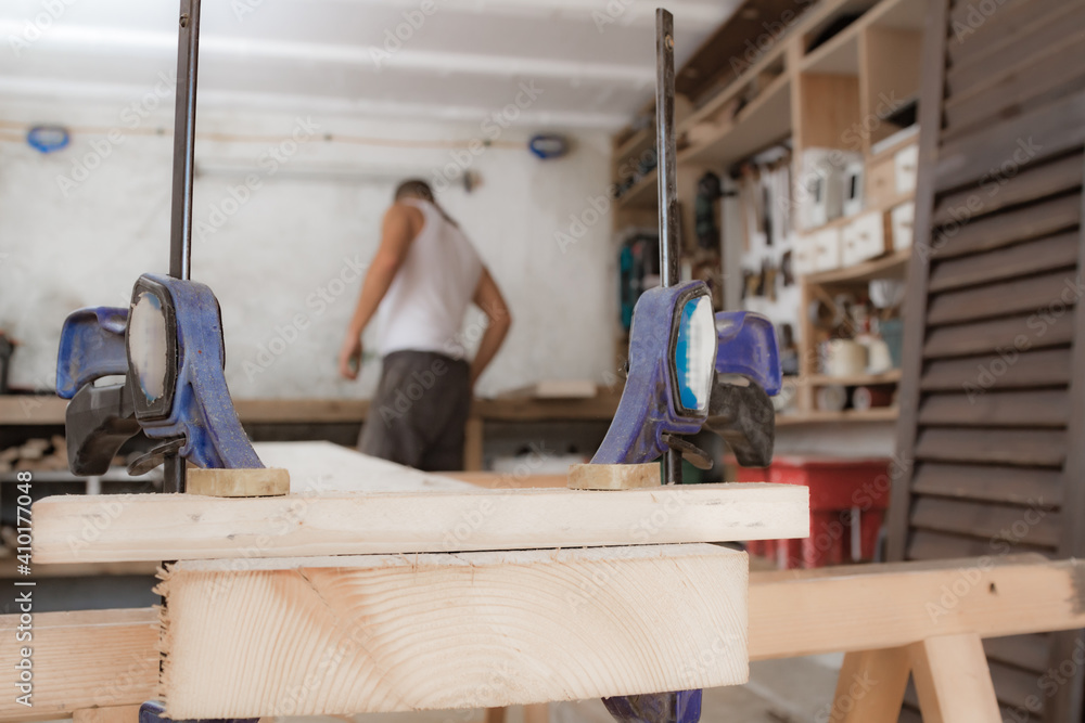 Fototapeta premium Male carpenter working with wood material in a garage.