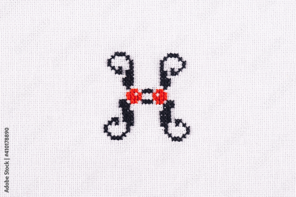 Letter H of Embroidered Cross - Stitch Latin Alphabet on White Linen Fabric Handmade Close-up Letter H of Embroidered Cross - Stitch Latin Alphabet on White Linen Fabric Handmade Close-up