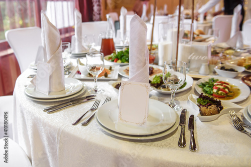 Table setting with sparkling wineglasses, plate with white napkin and cutlery on table, copy space. Place set at wedding reception. Table served for wedding banquet in restaurant