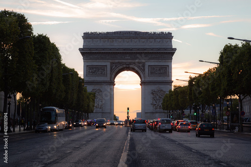 Motor traffic along the Champs-Elysees towards the famous landmark Arc dr Triomphe on a summer's evening in Paris, France. photo