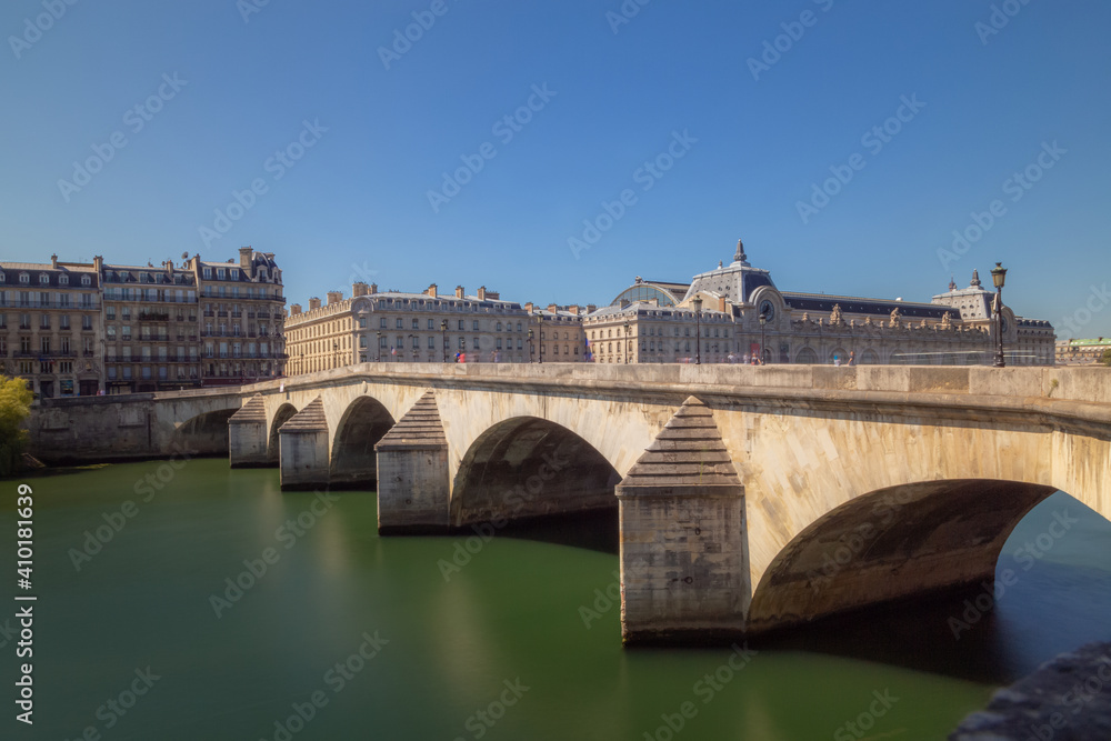 The Pont du Carrousel leading to the Louvre over the River Seine on a cleary sunny day in Paris, France