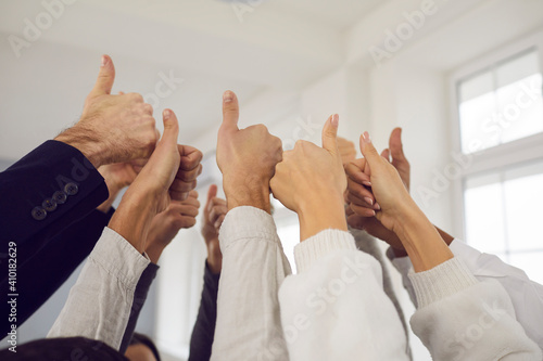 Business team, Success, thumbs up gesture concept. Hands of business partners workers of mixed ethnicity showing thumbs up sign meaning successful cooperation and project development photo