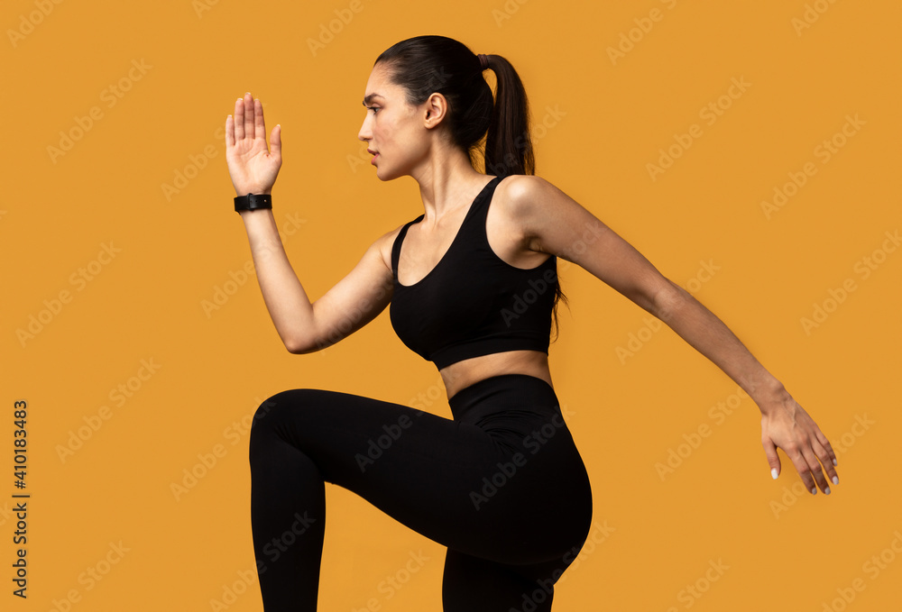 Young Woman Running And Exercising Isolated On Orange Background Young Woman Running And Exercising Isolated On Orange Background