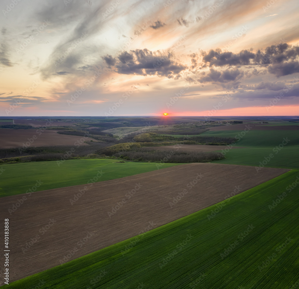 Aerial view of green agriculture field at sunset. Nature background.