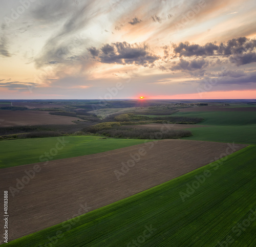 Aerial view of green agriculture field at sunset. Nature background.