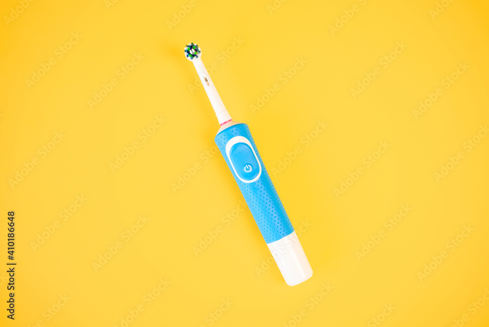 Smart electric toothbrush on a bright yellow background, top view. Modern tool for oral health. Vibrating brush head. Smart electric toothbrush on a bright yellow background, top view. Modern tool for oral health. Vibrating brush head.