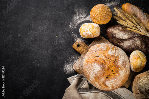 Fresh bread and buns black table. Top view image. photo