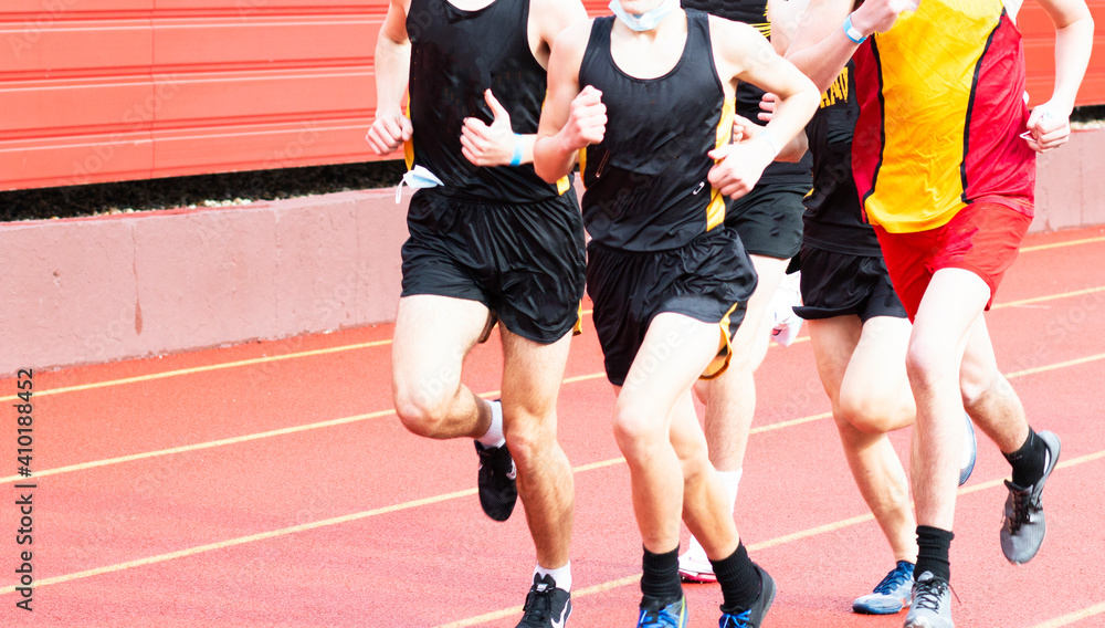 Boys running a race on a red track outdoors Boys running a race on a red track outdoors
