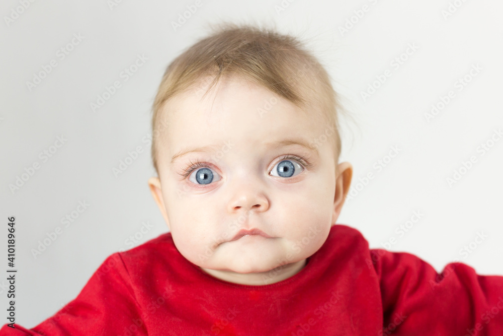 Portrait of a handsome kid with big blue eyes on a white background.