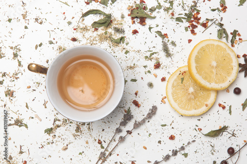 Herbal tea, top view. Dry herbs, lemon slices and tea cups on white. Herbs in bulk, zero waste and eco-friendly lifestyle, herbal medicine concept.