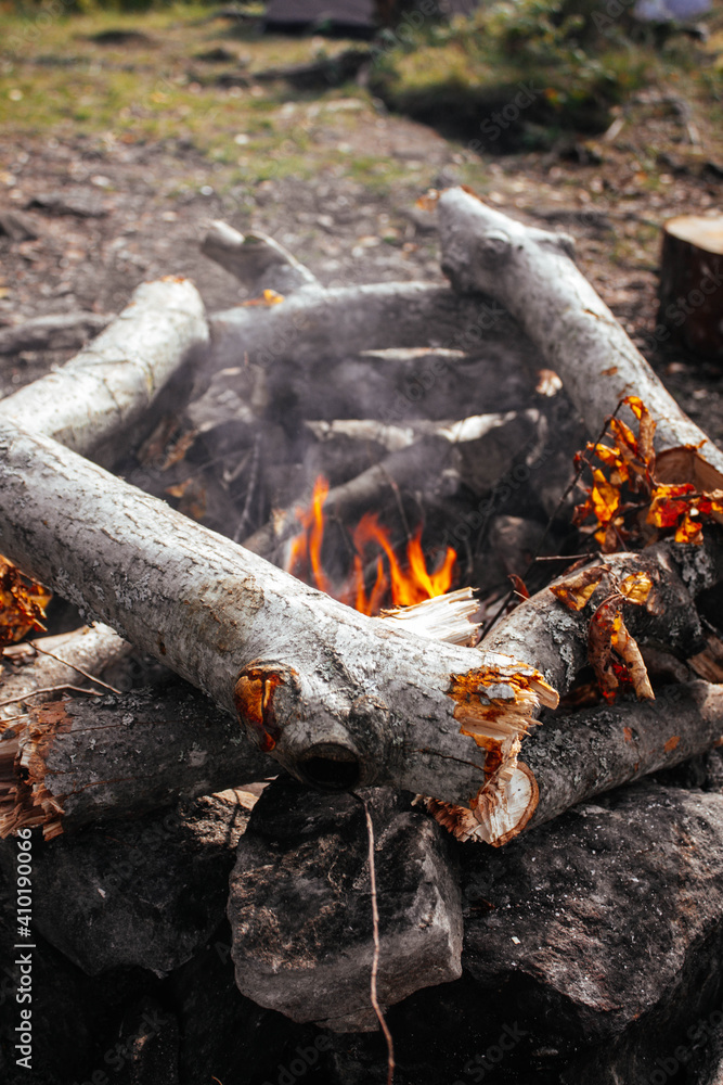 Fototapeta premium Orange campfire beautifully laid out logs around