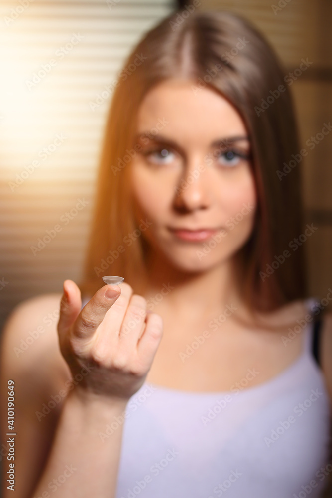 young girl holding a contact lens in the bathroom young girl holding a contact lens in the bathroom
