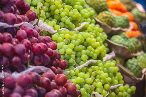 Purple and green grapes for sale at an indoor market in Barcelona, Spain.